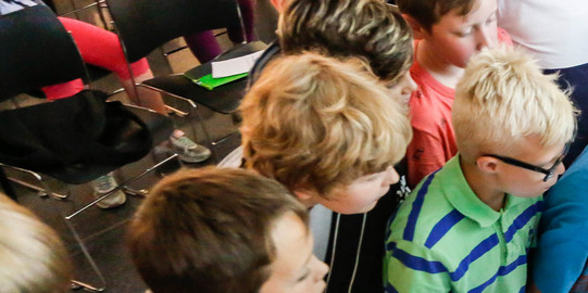 KinderUni im U Kinder im Grundschulalter schauen sich Versuchsanordnung an