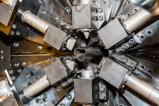 Maschinenbau_07 Ein Metallrohr wird in einer Maschine geformt.