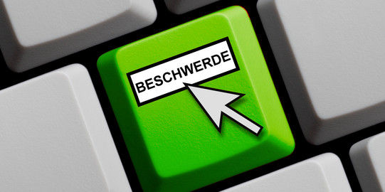 Beschwerde Eine grüne Taste mit dem Wort Beschwerde und einem hinweisenden Mauspfeil.