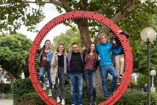 Studierende im Zahnrad Studierende haben sich in einem Zahnrad aufgestellt und zeigen ihre "Daumen hoch!"