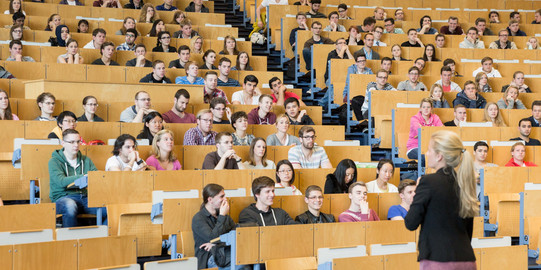 Students in the lecture hall_03 A lecturer stands in front of students in the lecture hall.